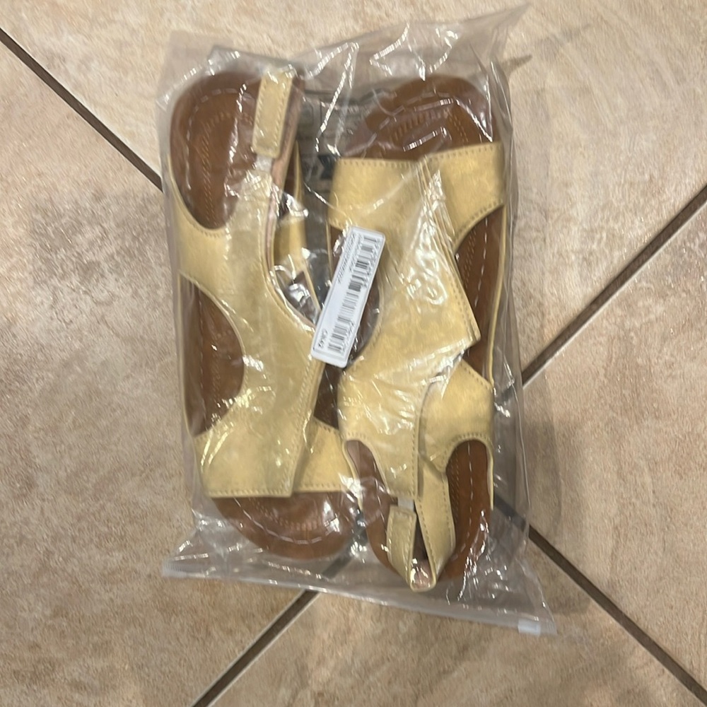 Manmade upper. Said size 10 but a small 9.5-9. Light yellow, plastic bottom.